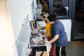 two mature woman same sex couple cooking dinner together, lifestyle people concept