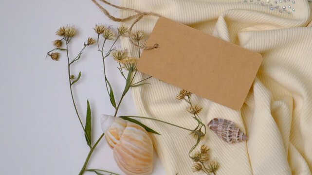 Blank brown paper price tag or label on pastel beige textile, fabric. Space for text. Gift tag, sale tag. Shopping