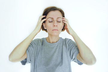 Woman performing a bilateral temple massage with closed eyes for migraine relief therapy....