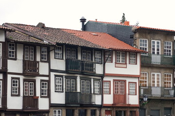 A rainy and cloudy day at Largo da Oliveira in Guimaraes, Portugal, showing the historic square with wet stone streets and medieval architecture.