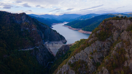Aerial photography of Vidraru dam, in Romania. Photography was shot from a drone from above canyon at Vidraru lake with the dam and the lake in the view and mountains in the background.