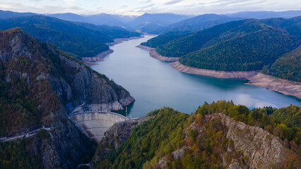 Aerial photography of Vidraru dam, in Romania. Photography was shot from a drone from above canyon at Vidraru lake with the dam and the lake in the view and mountains in the background.