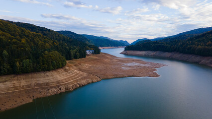 Wide angle photography of Lake Vidraru in Romania taken from a drone. Photography was shot from a higher altitude, and it can be seen the dried lake bed.