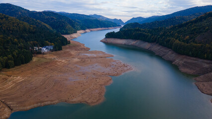 Wide angle photography of Lake Vidraru in Romania taken from a drone. Photography was shot from a higher altitude, and it can be seen the dried lake bed.
