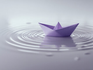 Purple paper boat floating gently on calm water creating circular ripples in a serene and minimalist setting with soft lighting and reflections