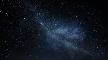 Obraz premium Bright stars and distant galaxies fill the night sky above. The dark landscape below contrasts with the shimmering celestial bodies. It is a clear evening perfect for stargazing.