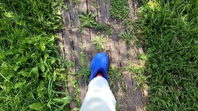 Garden boardwalk walk blue clogs and grass top view calm yard scene