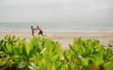 Dad and son play on the beach by the sea