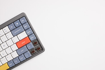 Close-up of colorful mechanical keyboard with removed keycaps showing brown switches on white background
