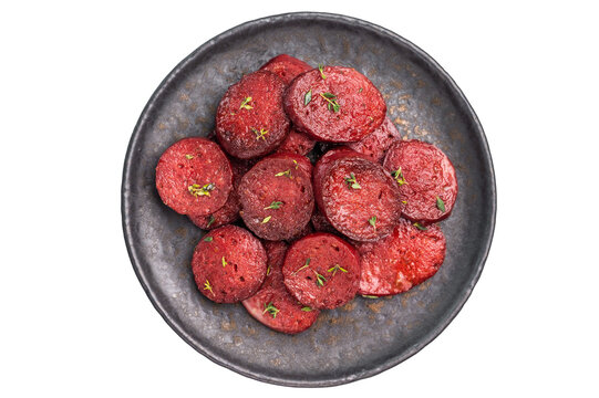 Pan-fried Turkish sucuk (sujuk) slices garnished with thyme on a dark plate. Spicy sausage breakfast or appetizer.