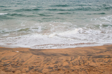Beautiful beach water foam, beach landscape. Serene sea atmosphere of waves.