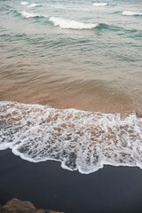 Beautiful beach water foam, beach landscape. Serene sea atmosphere of waves.