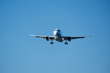 White Plane Approaching Runway Against Blue Sky