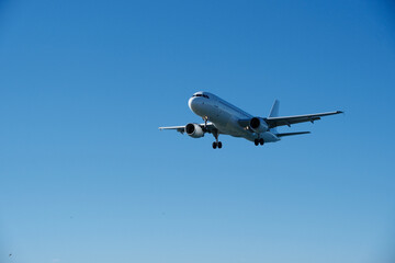 White Plane Approaching Runway Against Blue Sky