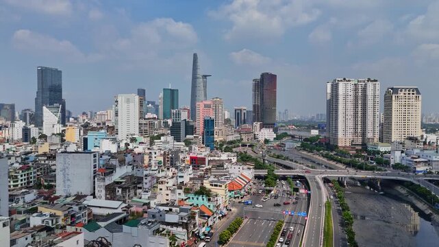 Wide drone view of central Ho Chi Minh City with Landmark 81 visible in the background and dense low-rise housing in foreground.