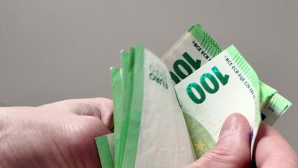Hands count a large stack of hundred euro banknotes