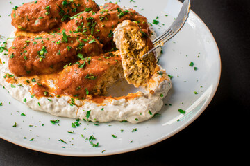 Traditional Mediterranean Kebabs or Meatballs in Tomato Sauce Served Over Creamy Yogurt Dip