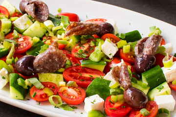 Traditional Greek Salad (Horiatiki) with Feta Cheese, Olives, Tomatoes, and Slices of Dry Cured Sausage