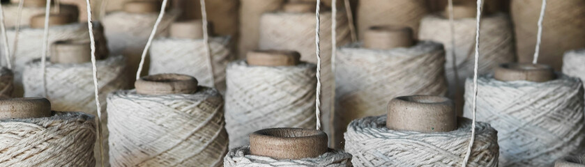 Naturl colored yarn spools in fabric production in textile factories.