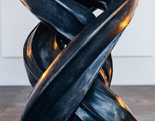 Striking abstract sculpture of interlocking dark metal forms. Modern art, complex design, strength, motion, flow, connection concepts. Perfect for backgrounds or visuals.