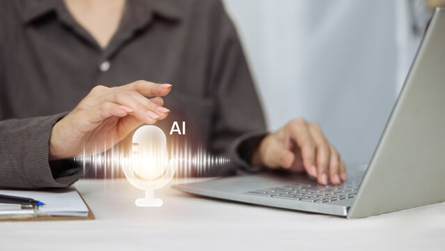 Business person typing on laptop with virtual AI microphone and sound wave icon.