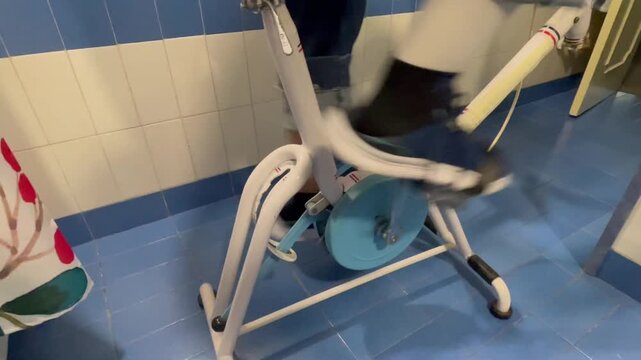pedaleando en bicicleta est&aacute;tica antigua vintage en rehabilitaci&oacute;n de rodilla 