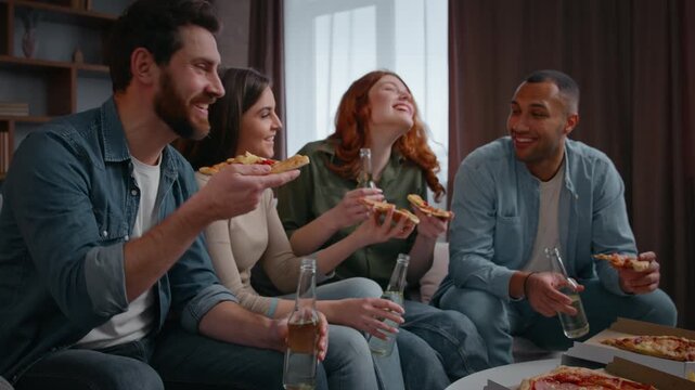 Group four diversity friends eating pizza talking positive drinking beer home party relaxing together hanging out indoors multiracial men women communicate enjoying drinks eat carefree happy meeting