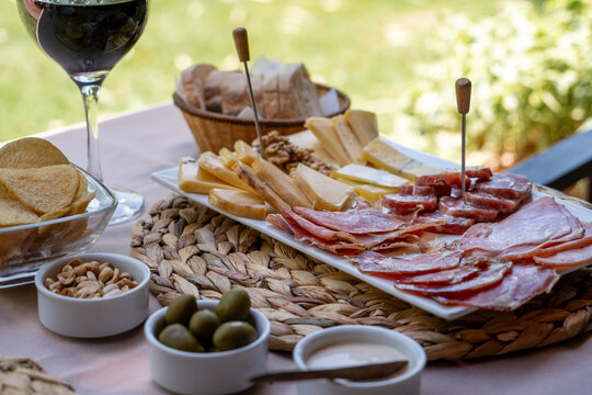 Deliciosa picada de quesos y embutidos premium, acompa&ntilde;ada de una buena copa de vino