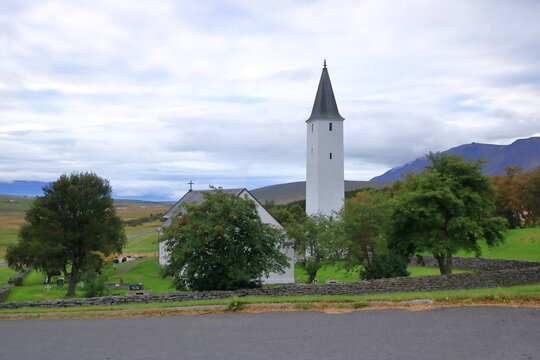 White church of Holar surrounded by a cemetery and green fields, Iceland