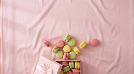 Colorful macarons in a pink gift box on soft fabric, perfect for sweet dessert themes.
