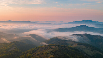Sunrise over misty mountain hills with low clouds in soft airy neutral tones, layered ridges fading into distance under pastel sky