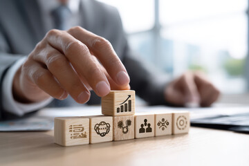 a close-up of hands in a business suit arranging wooden blocks with icons: growth, team, strategy, on a clean desk, soft natural light from window, modern office aesthetic