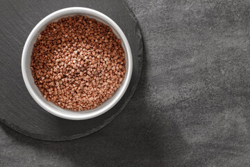 raw buckwheat groats in bowl, top view