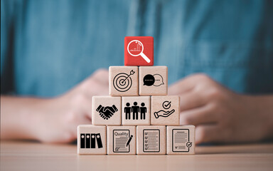 A quality audit concept using wooden blocks arranged in a pyramid illustrating compliance...