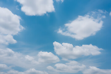 Celestial Canvas: Gentle clouds drift serenely against the vast expanse of a clear, azure sky, evoking a sense of calm and limitless space.