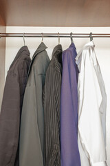 clothes, jackets, shirt  hanging on rack in closet
