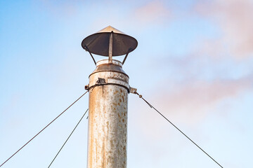 Obraz premium metal chimney close-up on tripwires against sky