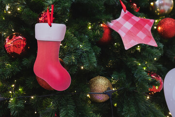 Red Christmas Stocking and Plaid Star Ornaments on a Green Christmas Tree