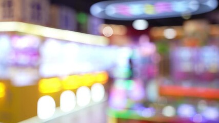 Defocused view of amusement Arcade game center. Toy crane game vending machine