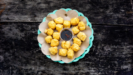 Fried tofu on the plate with hot soy sauce (sambal kecap)