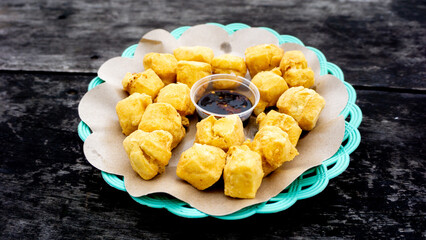 Fried tofu on the plate with hot soy sauce (sambal kecap)