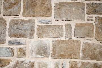 background consists of wall lined with rectangular old stones