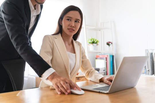 Disgusted asian young employee, pressure business woman uncomfortable, looking hand of boss or colleague when touching her shoulder, embrace. Sexual harassment inappropriate at office, workplace.