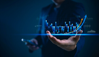 Businessman hand holding smartphone showing virtual hologram stock market graph chart. Finance investment trading concept. Digital technology economy growth profit rising arrow future success.