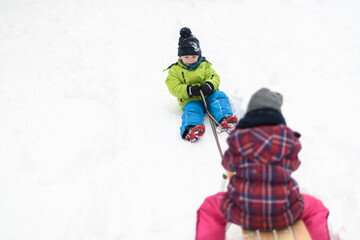 Beautiful Siblings Sledding on Snow