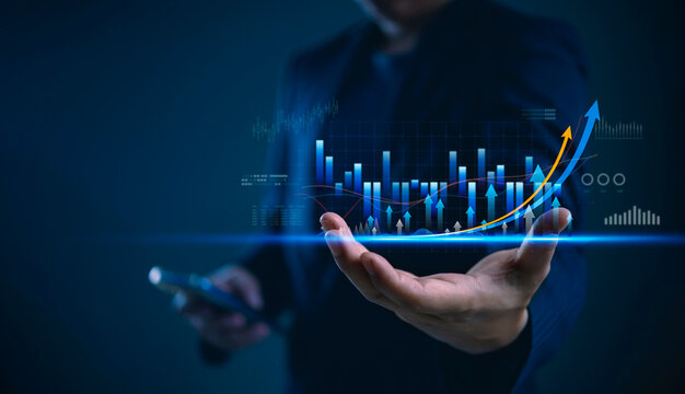 Businessman hand holding smartphone showing virtual hologram stock market graph chart. Finance investment trading concept. Digital technology economy growth profit rising arrow future success. - Powered by Adobe