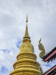 Fototapeta premium Majestic golden stupa standing beautiful buddhist temple Thailand, showcasing intricate asian architecture. Spiritual and religious pagoda offers serene experience, reflecting ancient heritage