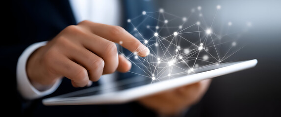 A business professional uses a tablet to interact with digital connections, showcasing modern technology and innovation.