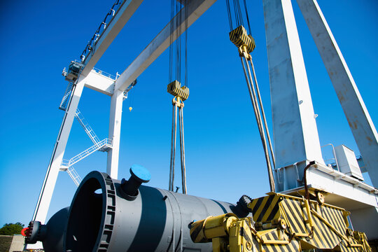 Harbor gantry crane moving a tank container