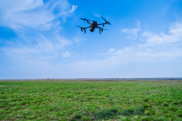 Drone with a camera flies against the background of sky